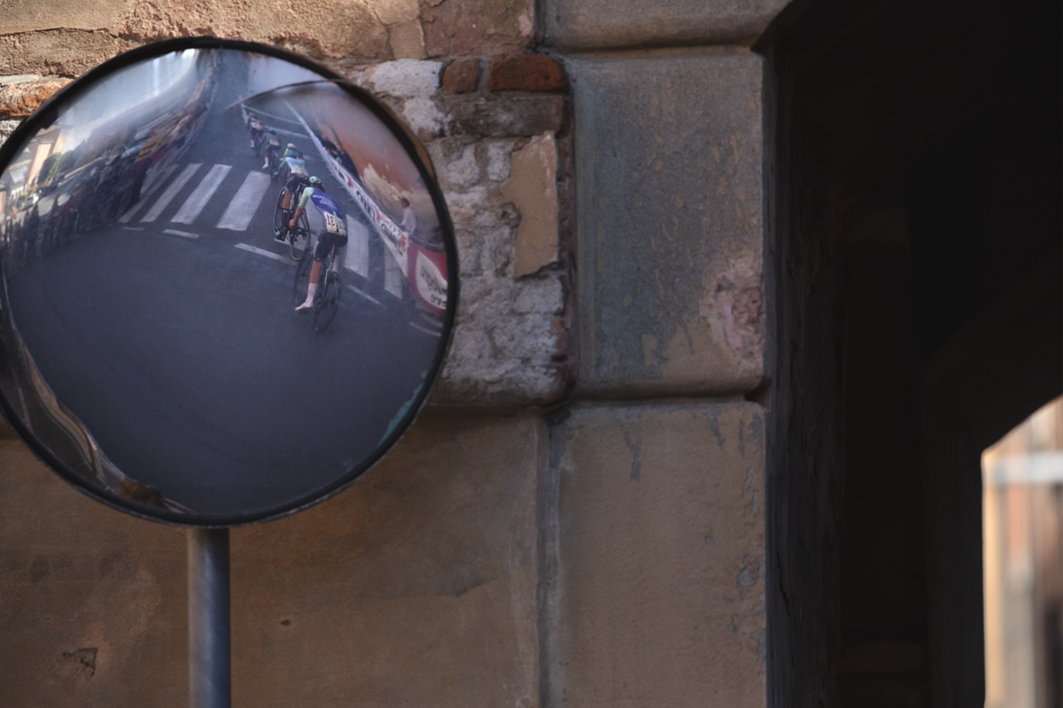 Giro dell’Emilia 2025 - Riders reflected in a mirror on the Via di San Luca