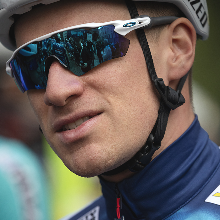 Giro dell’Emilia 2025 - Ethan Hayter, his team mates reflected in his glasses, waits for the team presentation