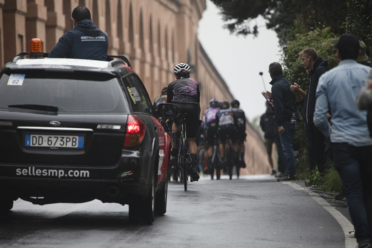 Giro dell'Emilia Internazionale Donne Elite 2024 - One of the last riders up the Via di San Luca is followed closely by a race official’s car