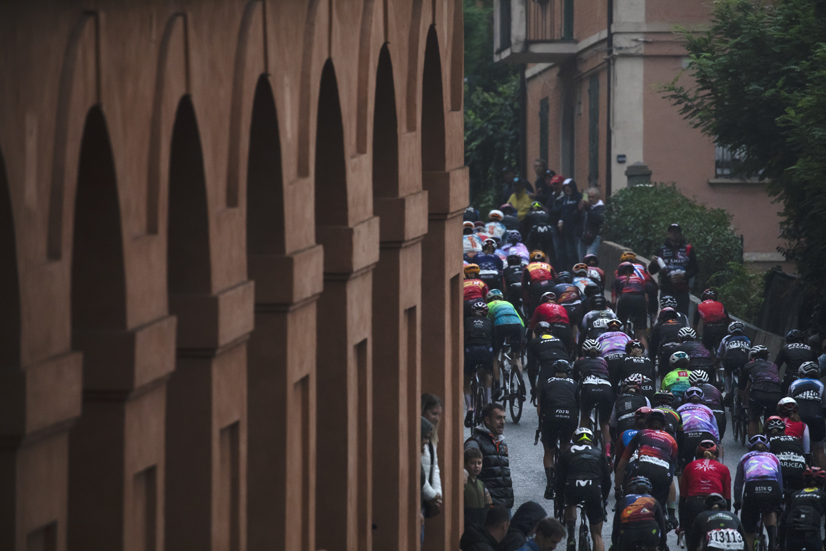 Giro dell'Emilia Internazionale Donne Elite 2024 - The peloton from behind as it passes the portico on Via di San Luca