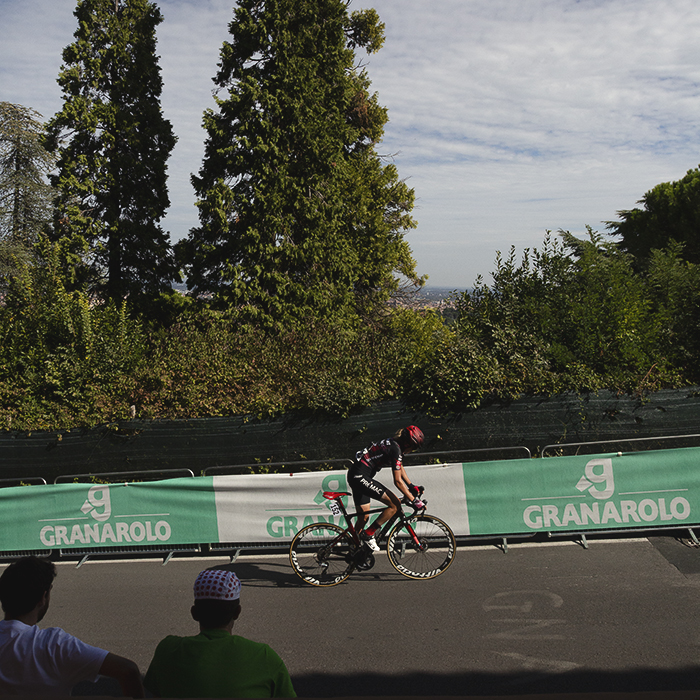 Giro dell'Emilia Internazionale Donne Elite 2025 - Valeria Curnis rides past fans watching from the shade of the portico