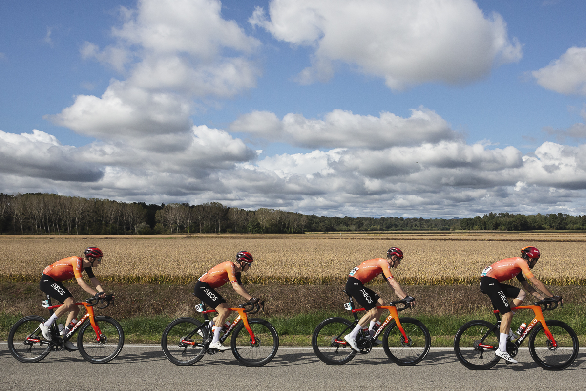 Gran Piemonte 2024 - A line of riders from INEOS Grenadiers with a backdrop of rice fields