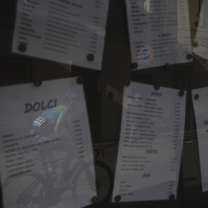 Gran Piemonte 2025 - Clément Champoussin is reflected in the menu board posted outside a restaurant in Acqui Terme