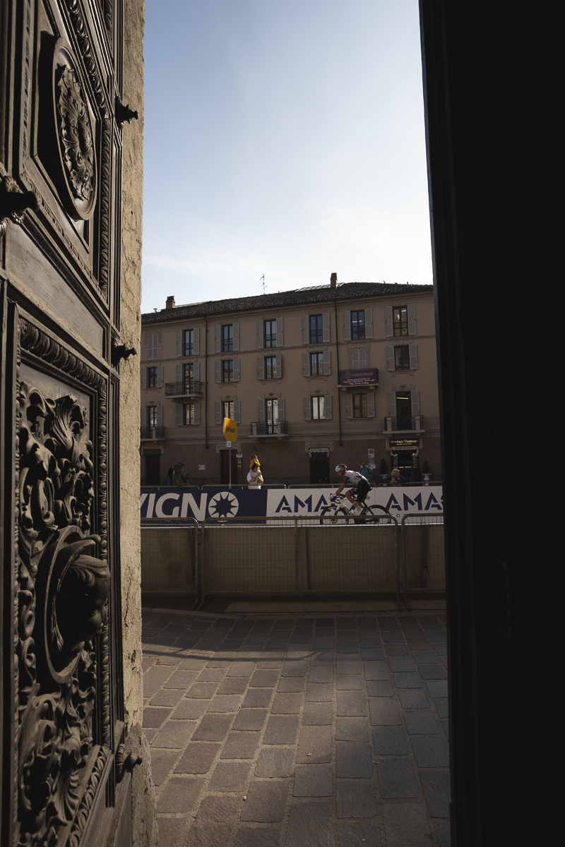 Gran Piemonte 2025 - Domen Novak is viewed though the ornate door of a church during the race