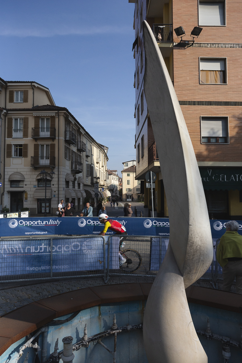 Gran Piemonte 2025 - Dylan Teuns passes an ornate fountain in Acqui Terme