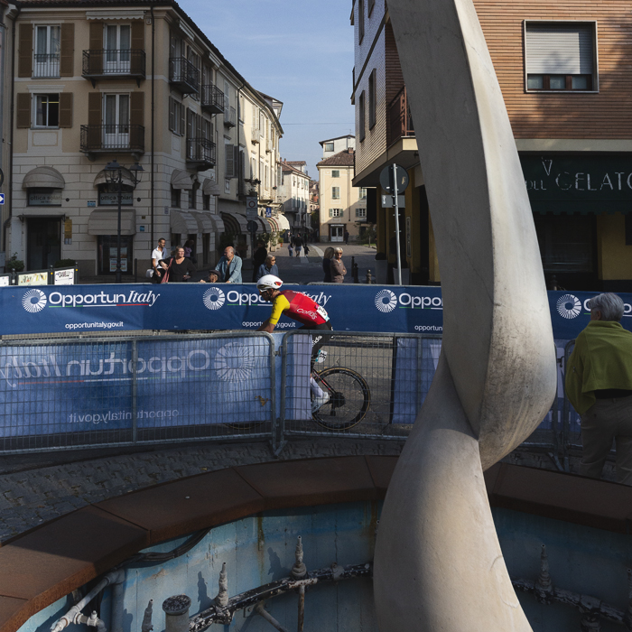 Gran Piemonte 2025 - Dylan Teuns passes an ornate fountain in Acqui Terme