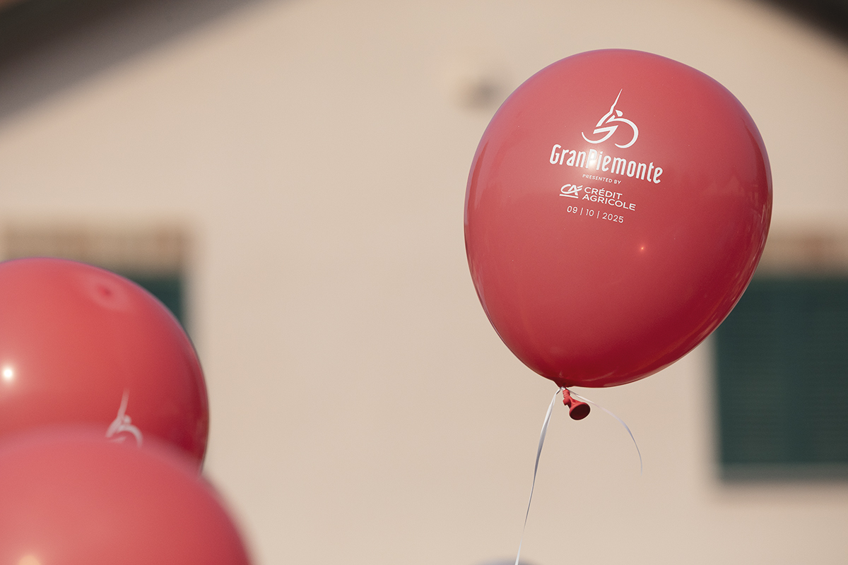 Gran Piemonte 2025 -  Red balloons float skyward at the start in Dogliani