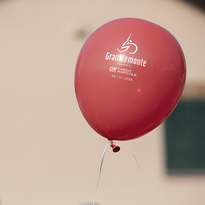 Gran Piemonte 2025 -  Red balloons float skyward at the start in Dogliani