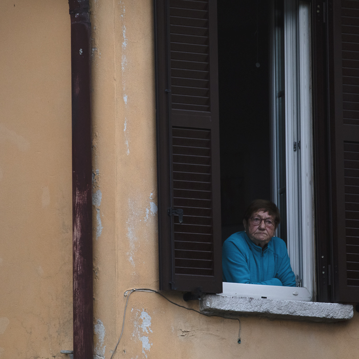 Il Lombardia 2024 - A fan watches out of the window of her home in Como