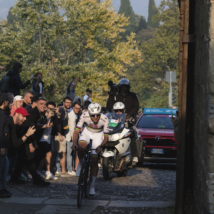 Il Lombardia 2025 - Tadej Pogačar is illuminated by late afternoon sunlight as he passes through the ancient gateway of Porta San Lorenzo