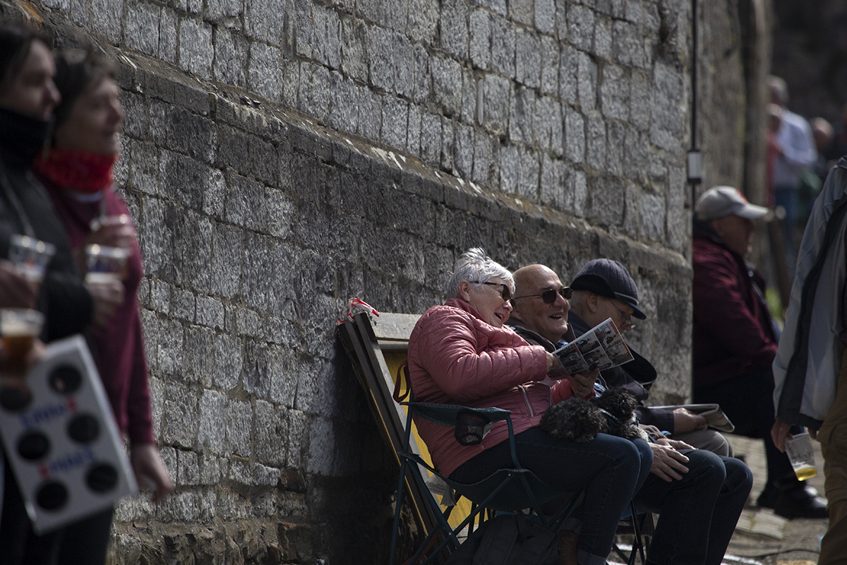 La Flèche Wallonne 2023 - An old couple sit and laugh as they wait for the race on the Mur de Huy