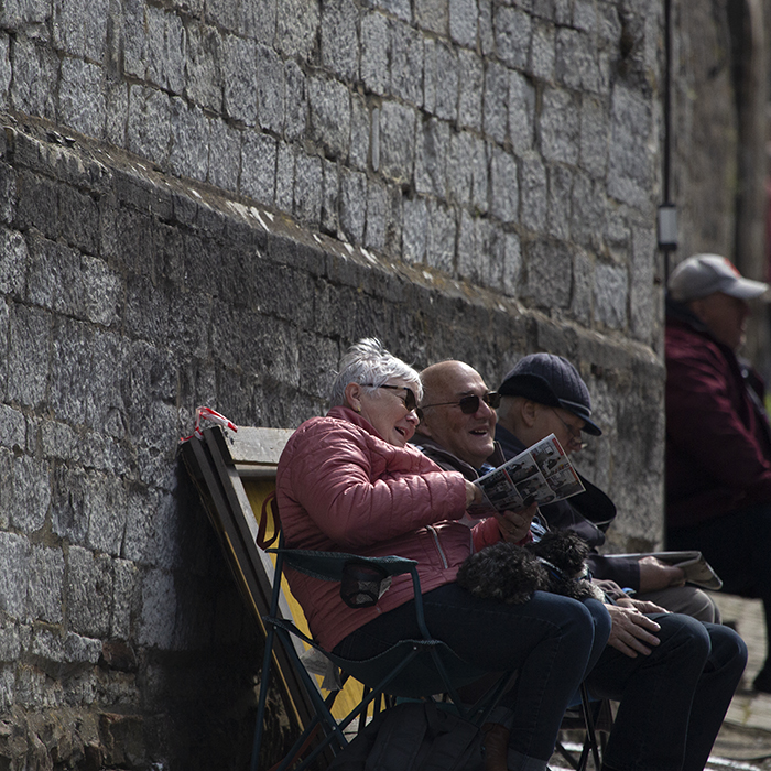 La Flèche Wallonne 2023 - An old couple sit and laugh as they wait for the race on the Mur de Huy