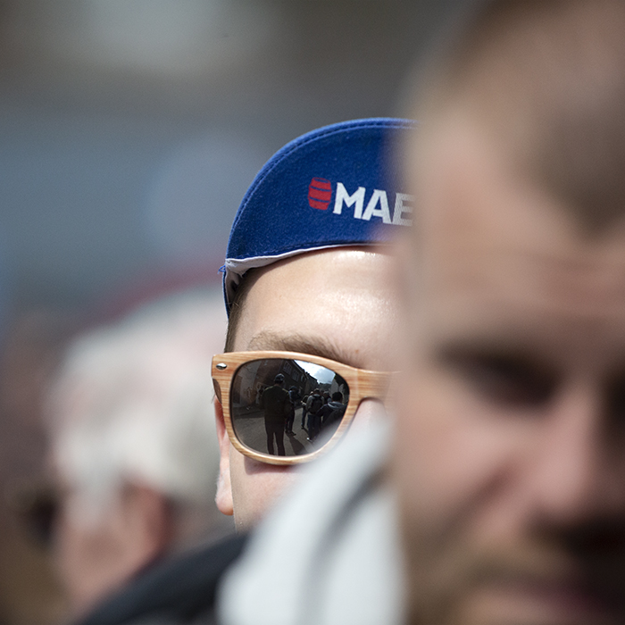 La Flèche Wallonne 2023 - Close up of a fan wearing cycling clothes and sunglasses with the Mur reflected in them