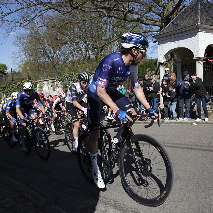 La Flèche Wallonne 2023 - The peloton passes one of the white chapels on the Mur de Huy