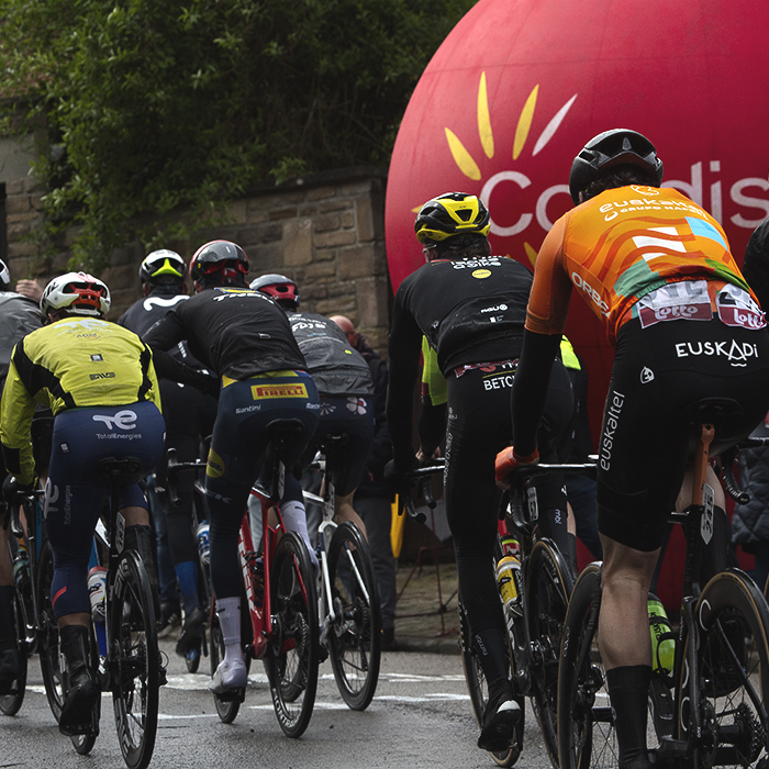 La Flèche Wallonne 2024 - Riders pass an advertising inflatable on the Mur de Huy