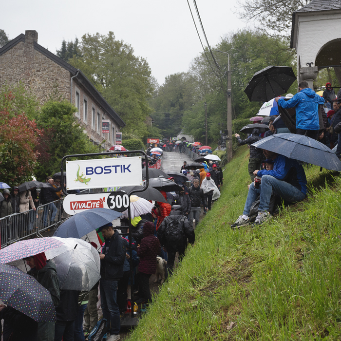 La Flèche Wallonne 2025 - Fans shelter under umbrellas as they wait for the race on the Mur de Huy