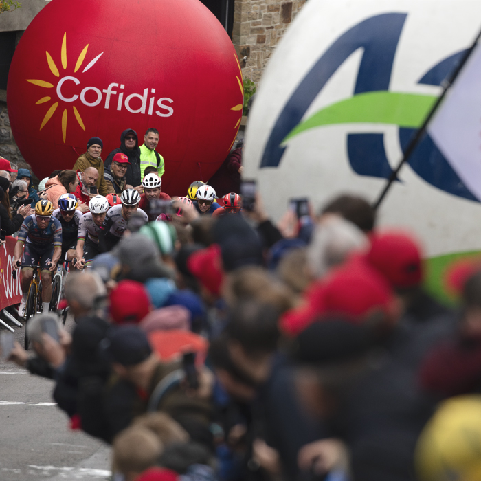 La Flèche Wallonne 2025 - Fans lean out to get a better view of the approaching peloton on the Mur de Huy