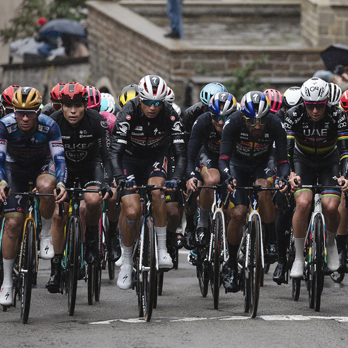 La Flèche Wallonne 2025 - The peloton on the Mur de Huy, riders covered in their rain jackets to protect against the challenging conditions