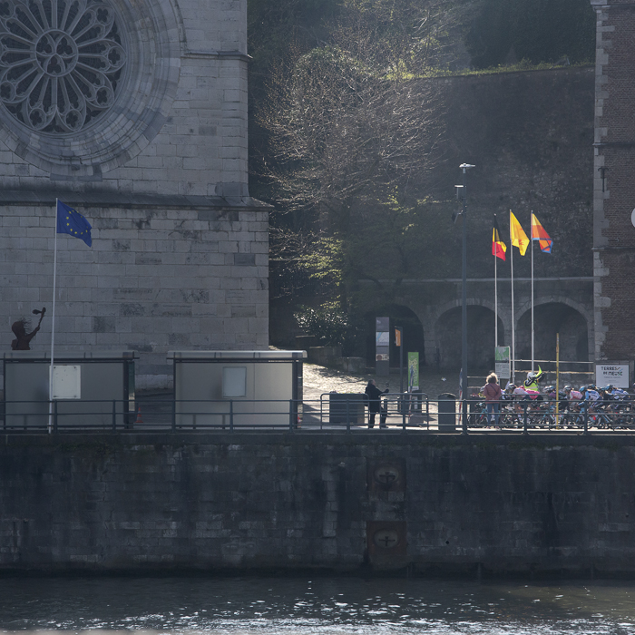 La Flèche Wallonne Femmes 2023 - The peloton is illuminated by a patch of light as it passes near the cathedral in Huy