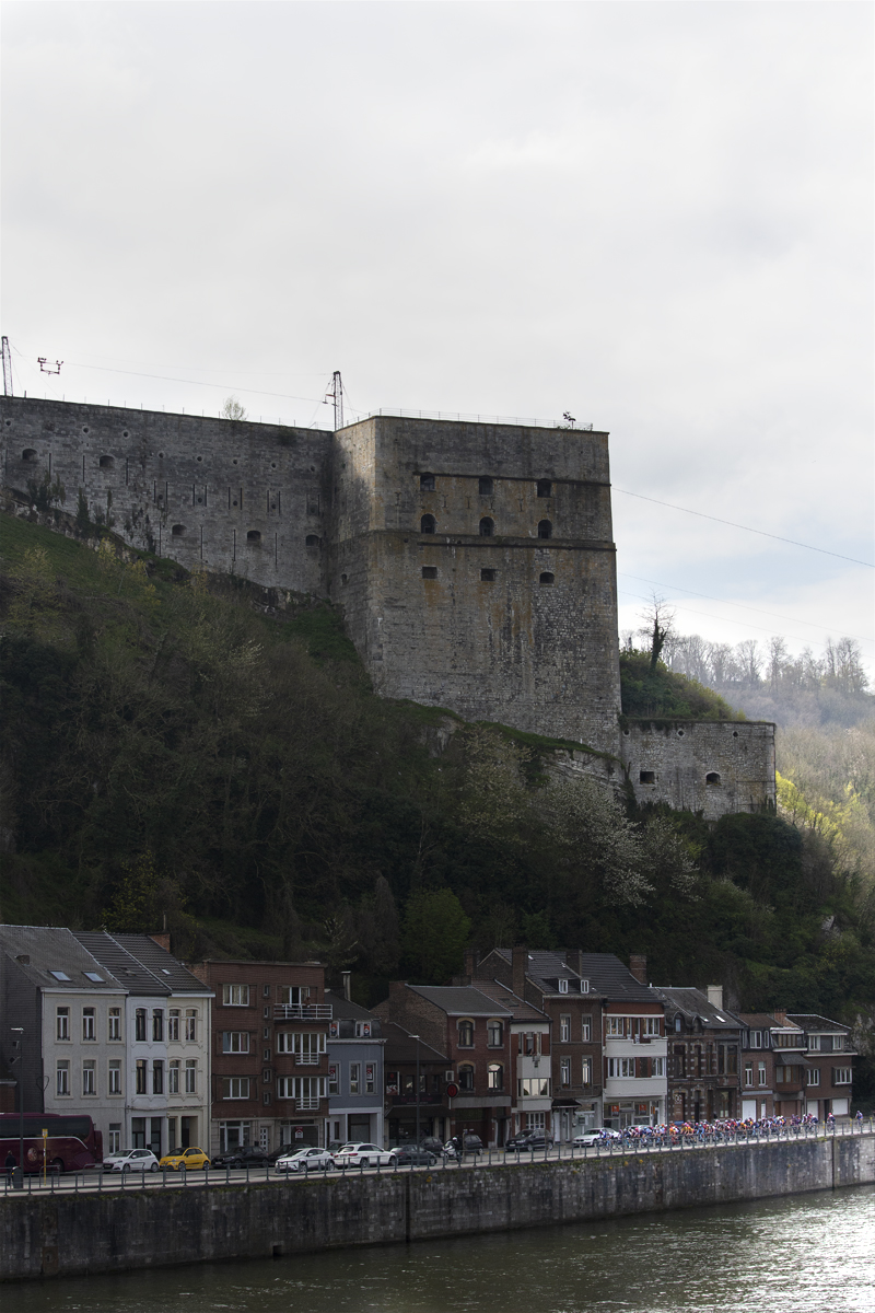 La Flèche Wallonne Femmes 2023 - The peloton rides along the River Meuse with the citadel in the background