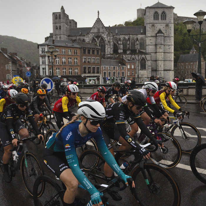La Flèche Wallonne Femmes 2025 - Collégiale Notre-Dame et Saint-Domitien is seen in the background as the race crosses the river