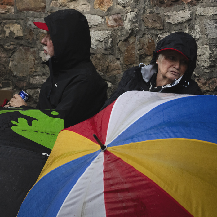La Flèche Wallonne Femmes 2025 - Fans sit with brightly coloured umbrellas waiting for the race