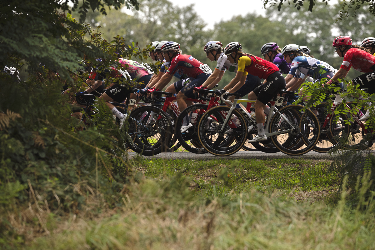 Classic Lorient Agglomération - Ceratizit 2025 - Riders are framed by a gap in a hedge in Brambanen