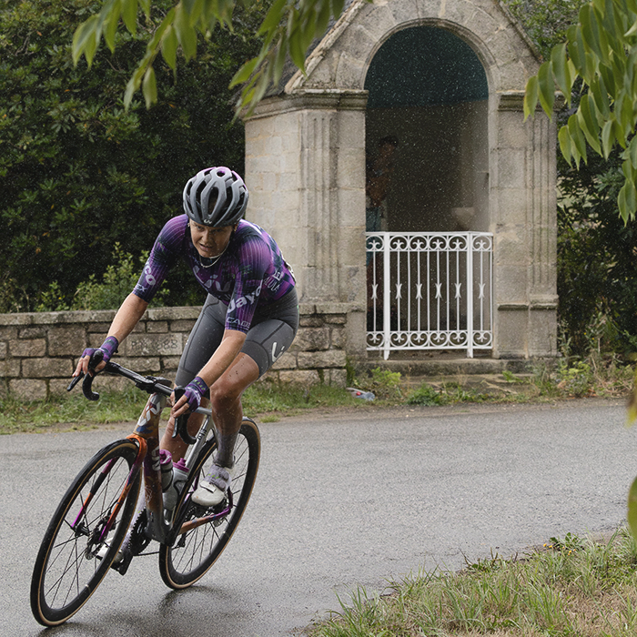 Classic Lorient Agglomération - Ceratizit 2025 - Jeanne Korevaar rides round a corner with a small roadside shrine in the background