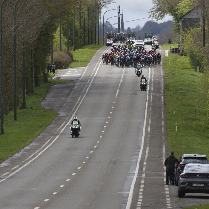 Liège-Bastogne-Liège 2024 - The peloton approaches down a long straight road at Vaux