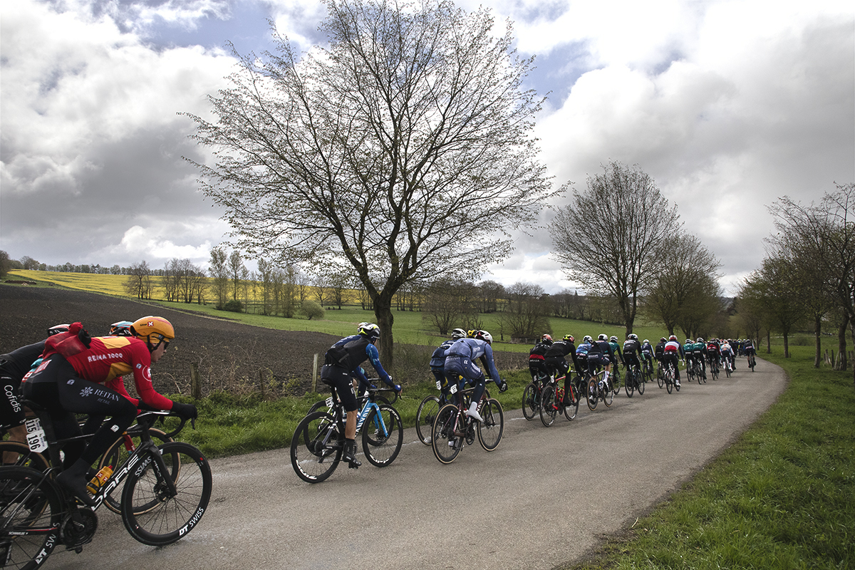Liège-Bastogne-Liège 2024 - Riders move down a tree lined road at Vaux