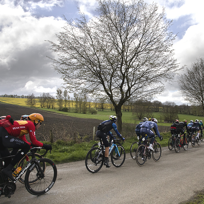 Liège-Bastogne-Liège 2024 - Riders move down a tree lined road at Vaux