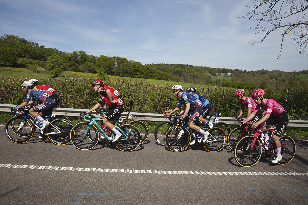 Liege Bastogne Liege 2025 - A group of riders pass a vista of open fields on Côte des Forges