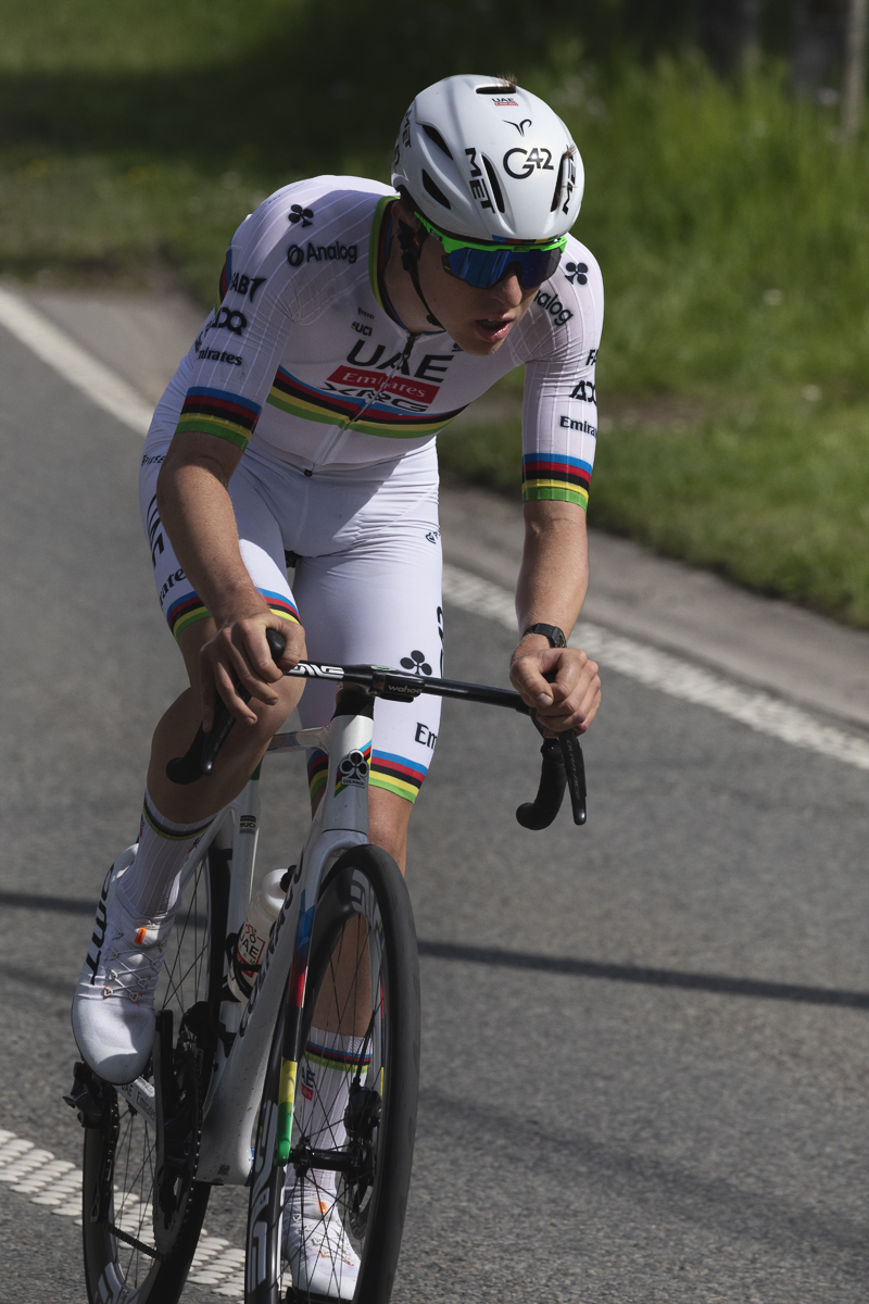 Liege Bastogne Liege 2025 - Tadej Pogačar wearing his all white World Champion’s kit is lit by strong sunlight