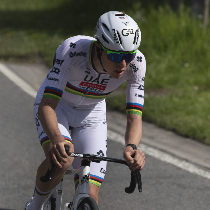 Liege Bastogne Liege 2025 - Tadej Pogačar wearing his all white World Champion’s kit is lit by strong sunlight