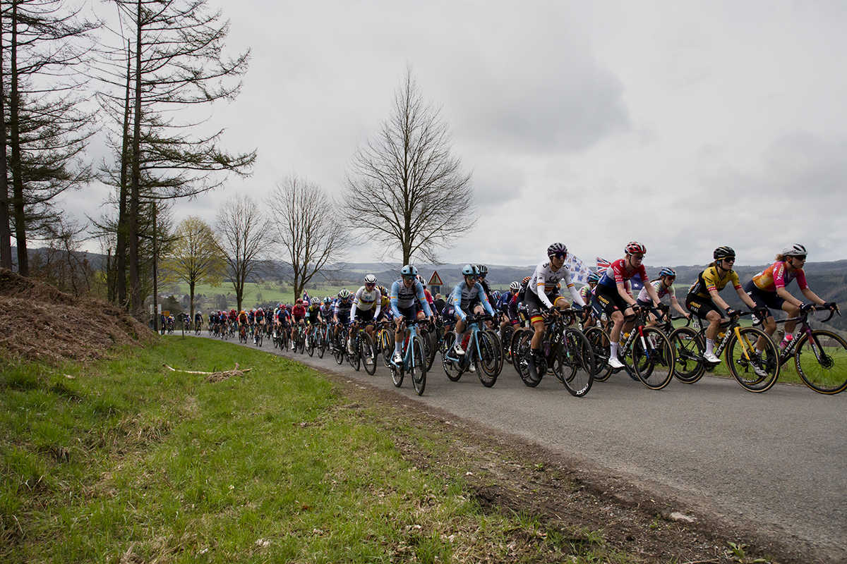 Liège-Bastogne-Liège Femmes 2023 - The peloton climbs the Côte de Wanne along Lavaux with the countryside of the Belgian Ardennes behind