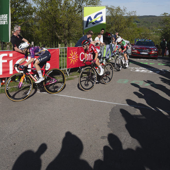 Liège Bastogne Liège Femmes 2025 - The shadows of fans are cast on the road as riders finish the climb