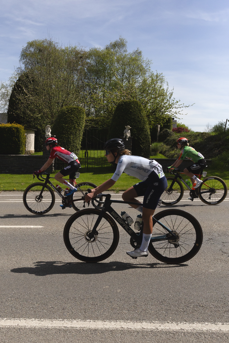 Liège Bastogne Liège Femmes 2025 - Riders pass neatly trimmed Belgian hedges at the entrance to a grand garden in Foy