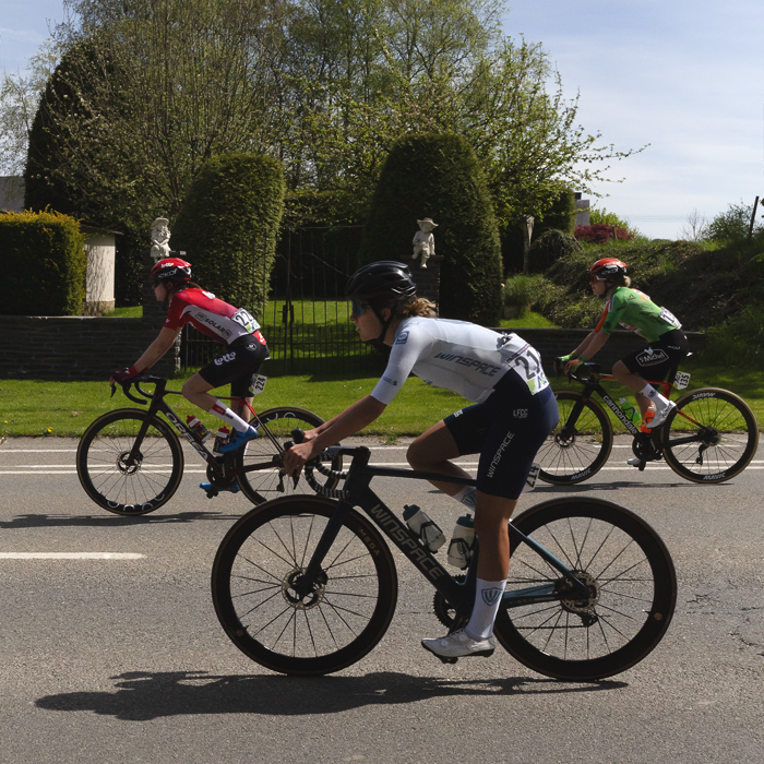 Liège Bastogne Liège Femmes 2025 - Riders pass neatly trimmed Belgian hedges at the entrance to a grand garden in Foy