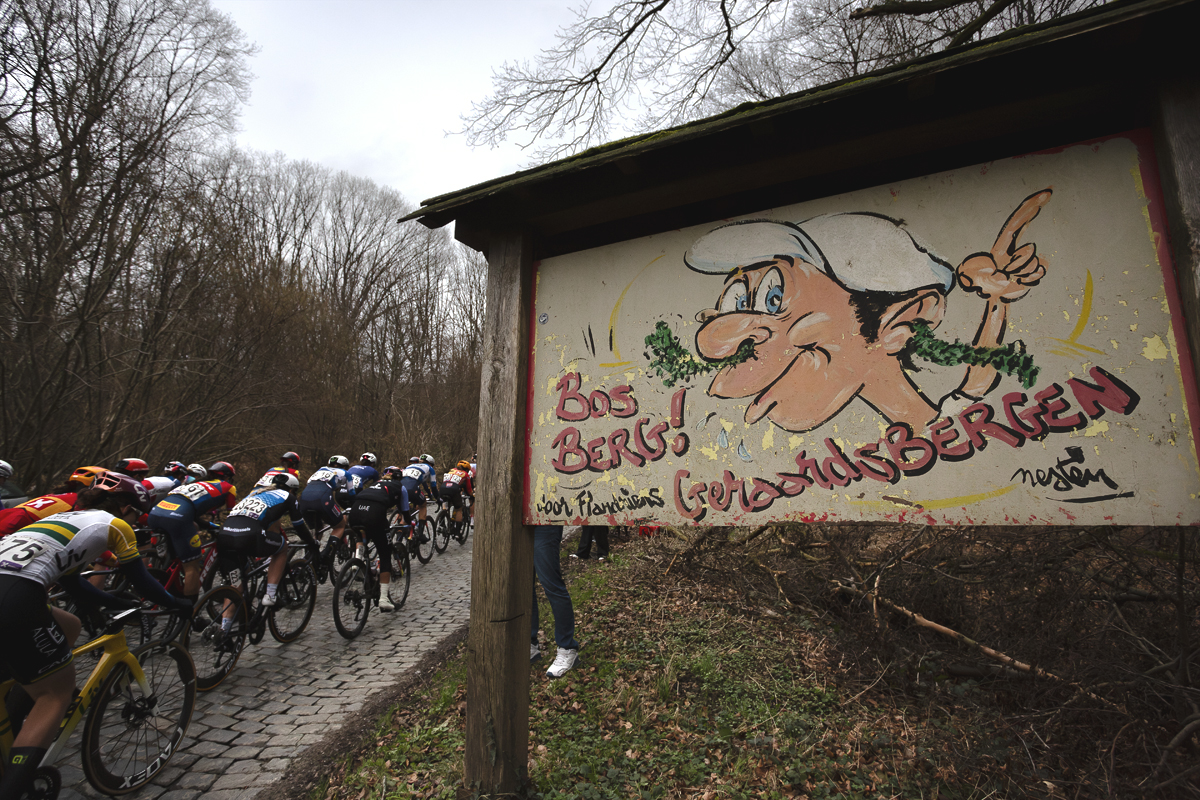 Omloop Het Nieuwsblad Vrouwen 2024 - The peloton passes the iconic old sign for the Bosberg