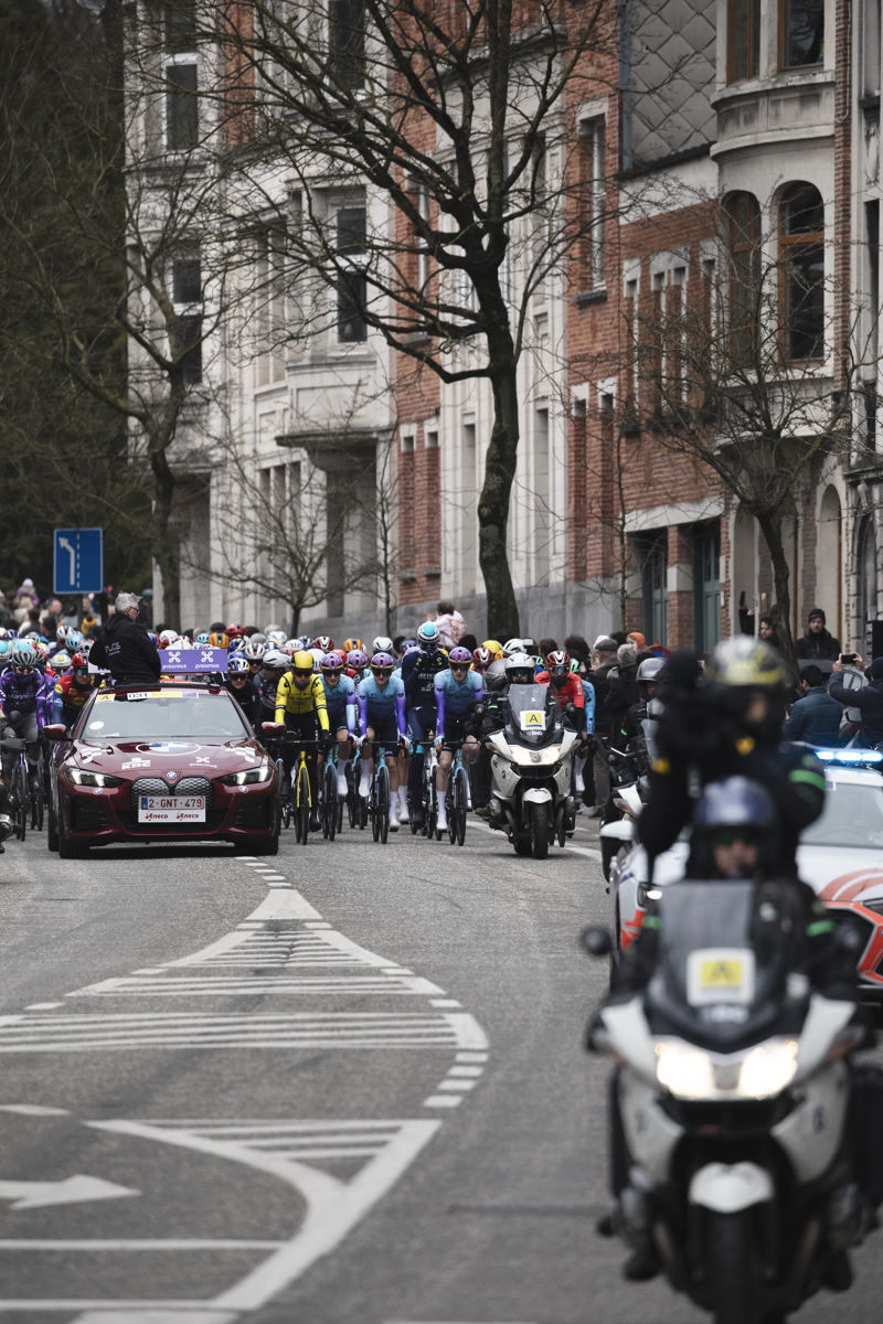 Omloop Nieuwsblad 2025 - Riders behind the Race Director’s car at the neutralised start in Gent