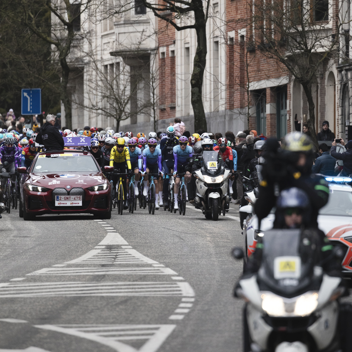 Omloop Nieuwsblad 2025 - Riders behind the Race Director’s car at the neutralised start in Gent