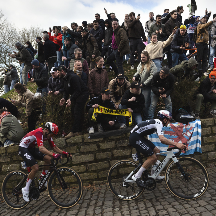 Omloop Nieuwsblad 2025 - Tom Pidcock of Q36.5 Pro Cycling Team & Arjen Livyns of Lotto, passes enthusiastic fans on the Muur van Geraardsbergen