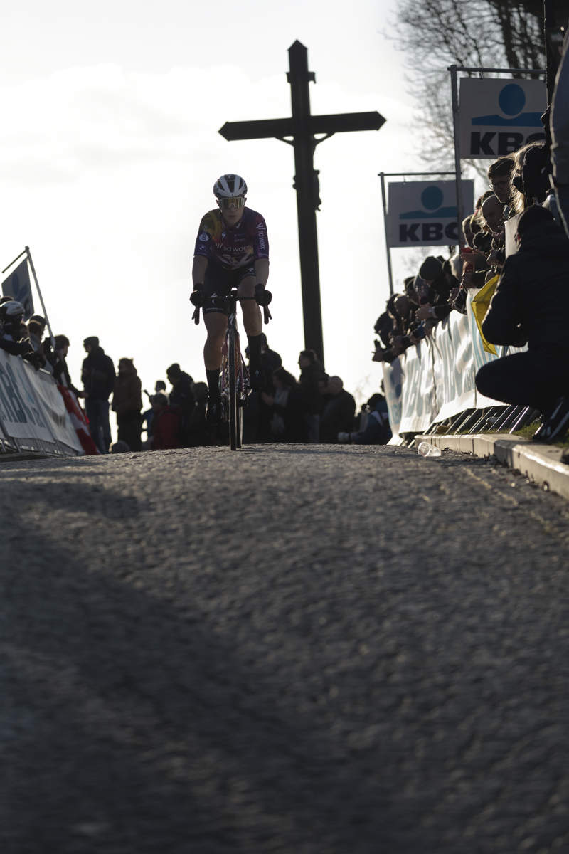 Omloop Nieuwsblad Vrouwen 2025 - Elena Cecchini, of Team SD Worx - Protime with the crucifix behind her as she crests the Muur van Geraardsbergen
