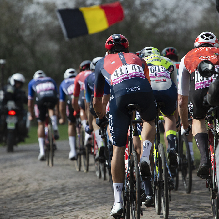 Paris Roubaix 2023 - A Belgian flag is waved as the riders move off the Wallers à Hélesmes cobbled sector