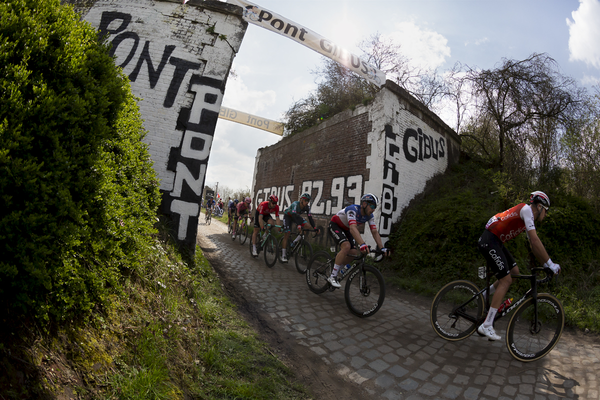 Paris Roubaix 2023 - A group of riders pass through Pont Gibus on the Wallers à Hélesmes sector