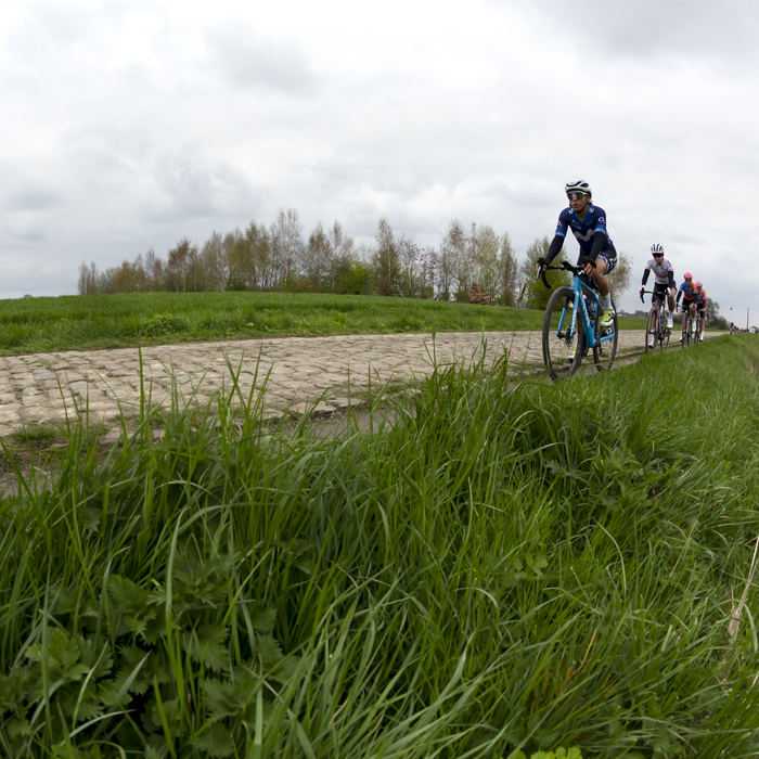 Paris Roubaix Femmes 2023 - Riders approach on the cobbles of the Auchy-lez-Orchies à Bersée sector