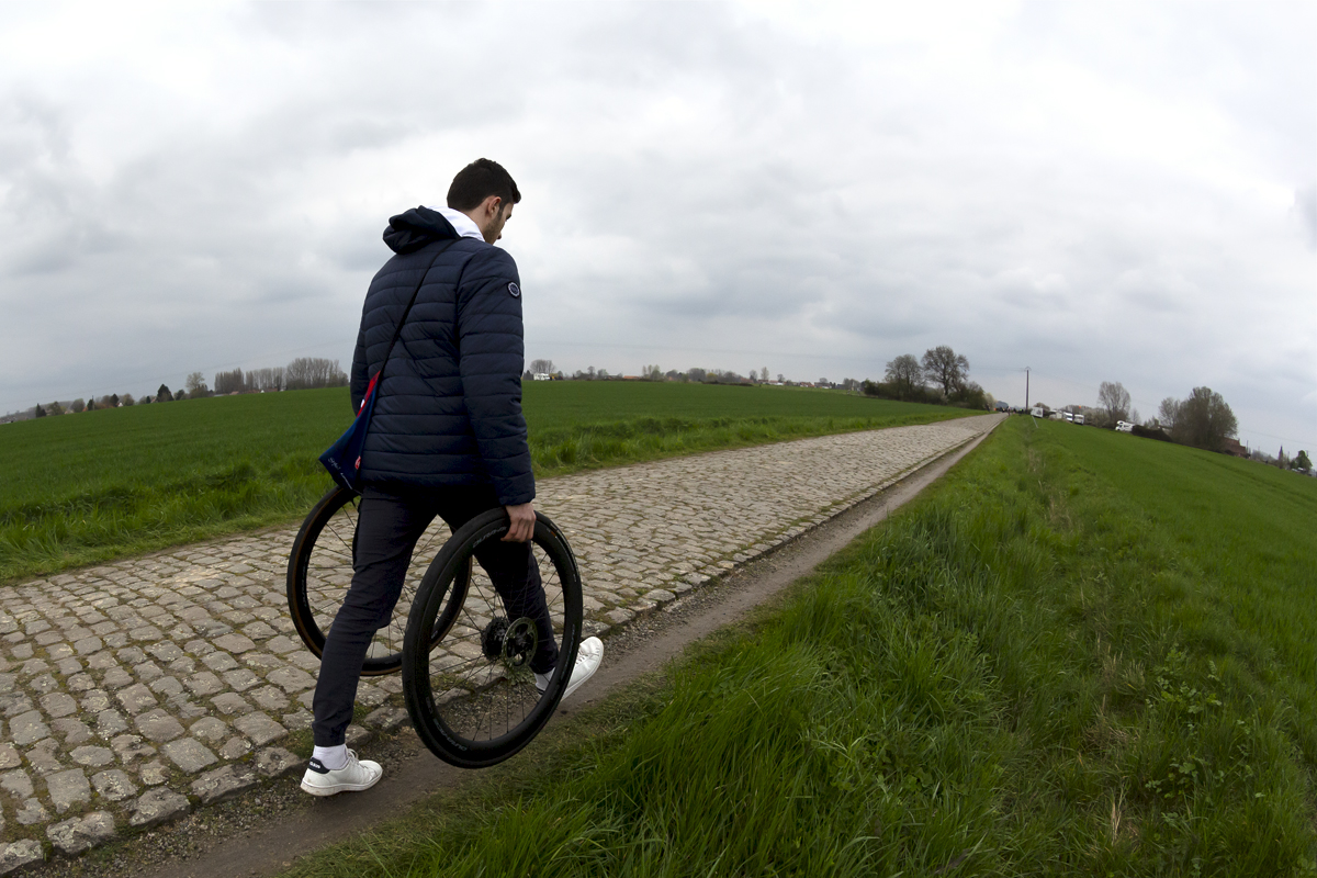 Paris Roubaix Femmes 2023 - A soigneur with wheels for the riders passes by