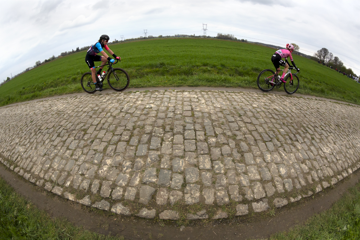 Paris Roubaix Femmes 2023 - A distorted shot of Sofie van Rooijen from Parkhotel Valkenburg and EF Education-TIBCO-SVB’s Lauren Stephens riding across the flat landscape