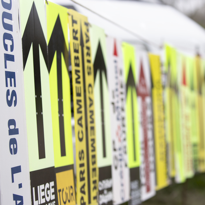 Paris Roubaix Femmes 2023 - Way markers from other races are displayed by fans at the side of the race