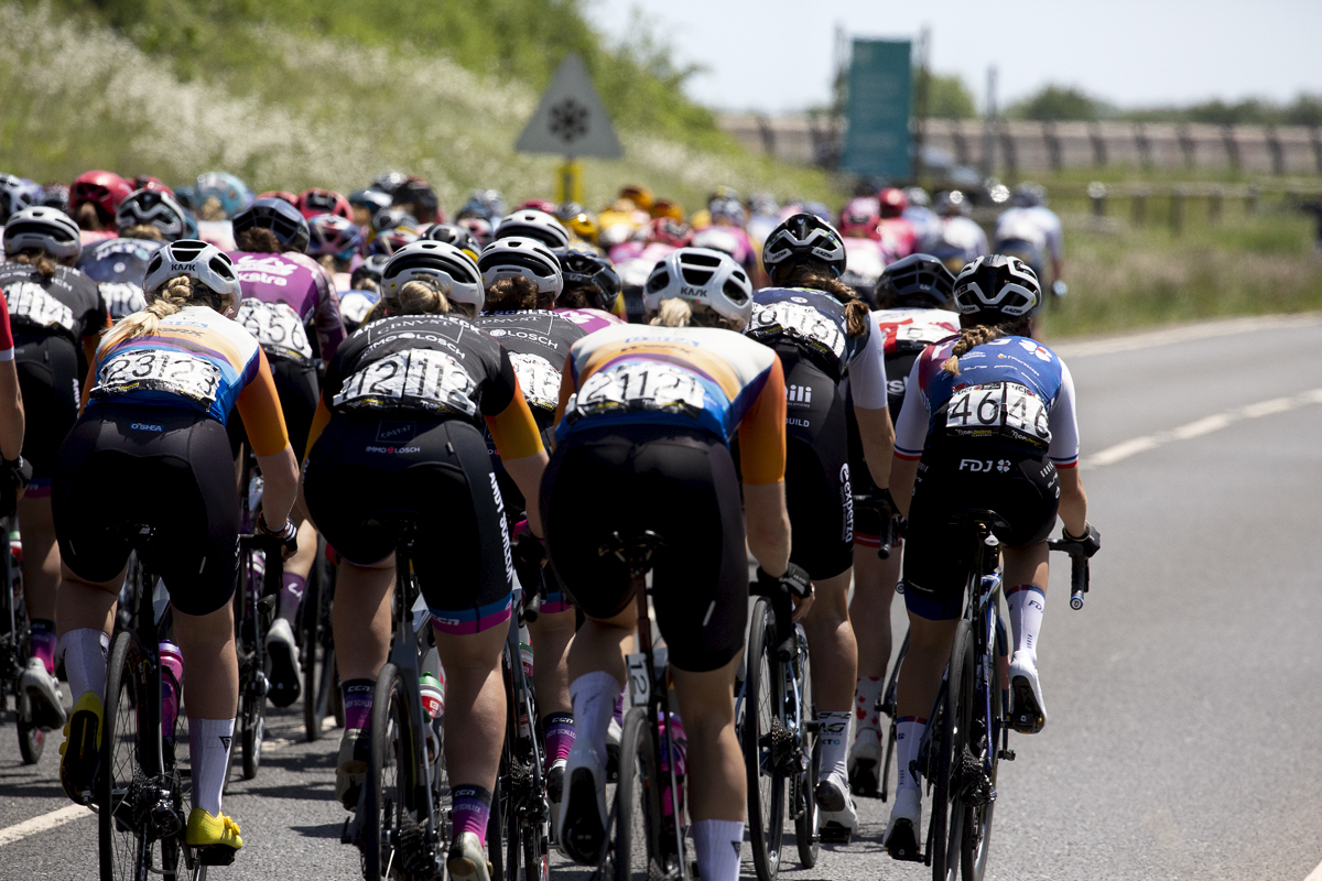 RideLondon Classique 2022 - The back of the peloton as it makes its way off the reservoir dam